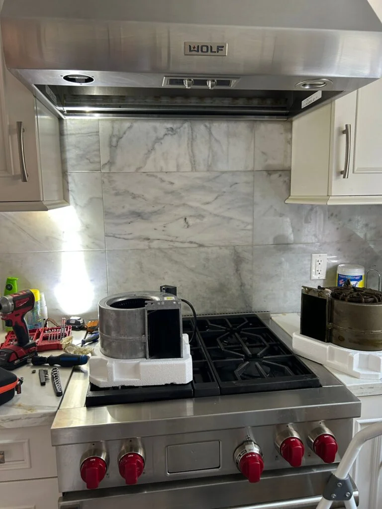 Appliance repair technician inspecting dryer components in Denver